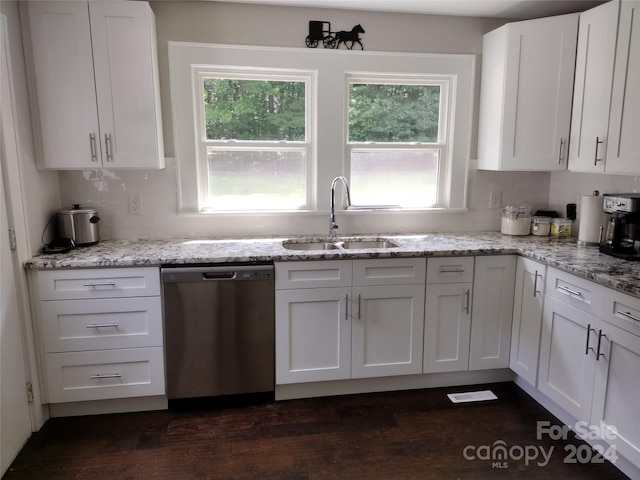 kitchen with dark hardwood / wood-style flooring, stainless steel dishwasher, sink, decorative backsplash, and plenty of natural light