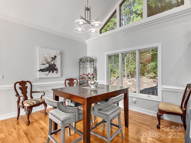 dining area with a textured ceiling, a wealth of natural light, light hardwood / wood-style flooring, and a notable chandelier