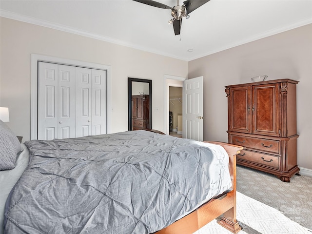 carpeted bedroom with washer / dryer, ceiling fan, ornamental molding, and a closet