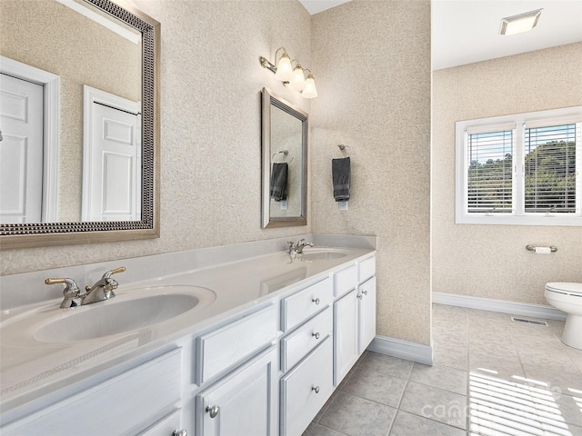 bathroom featuring toilet, vanity, and tile patterned flooring