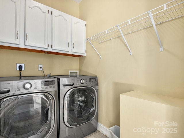 washroom with cabinets, light tile patterned floors, and washing machine and clothes dryer