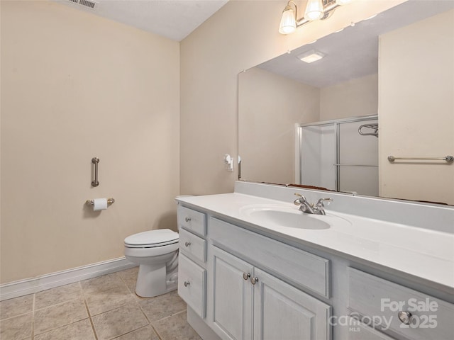 bathroom featuring a shower with shower door, vanity, tile patterned flooring, and toilet