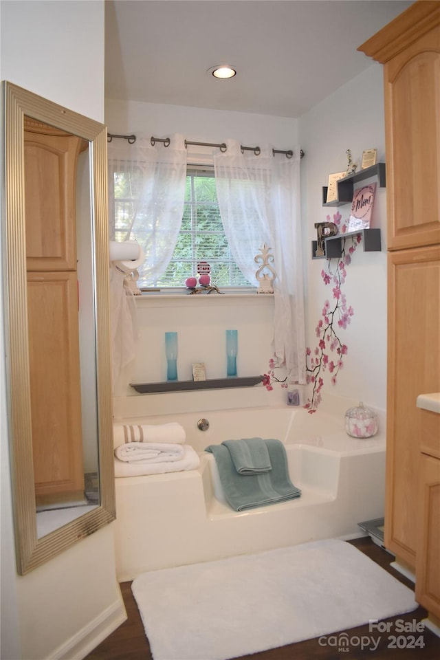 bathroom featuring a tub to relax in, wood-type flooring, and vanity