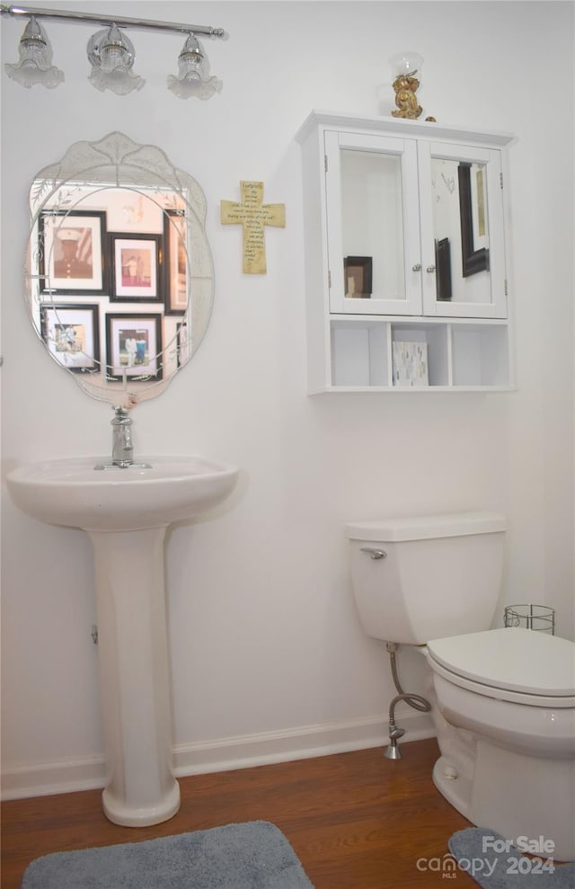 bathroom with toilet and hardwood / wood-style flooring