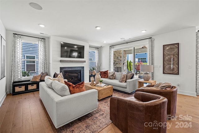 living room featuring light hardwood / wood-style flooring and a large fireplace