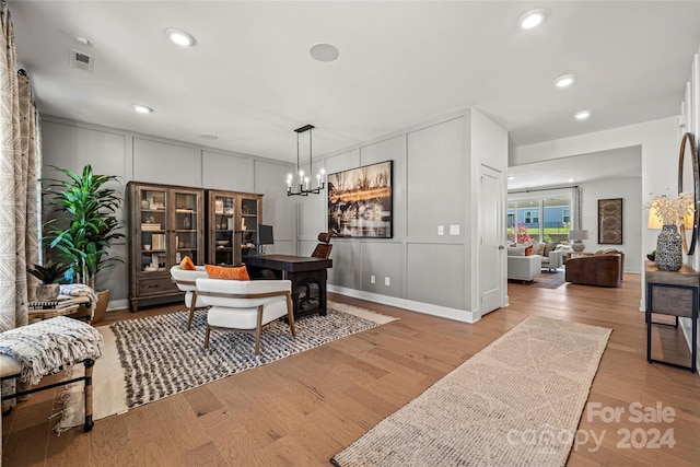 office space featuring light hardwood / wood-style floors and a chandelier