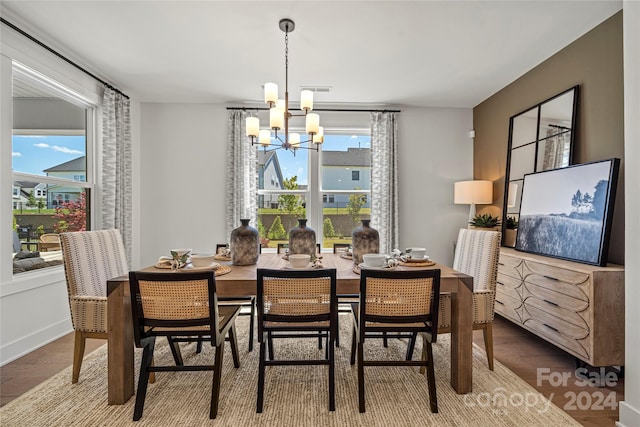 dining area with a notable chandelier and hardwood / wood-style floors