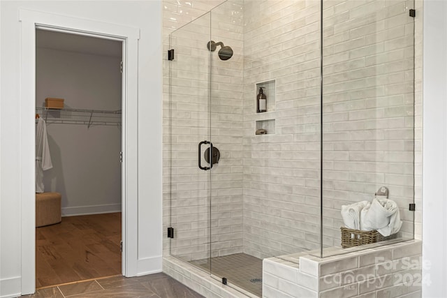 bathroom featuring a shower with door and hardwood / wood-style floors