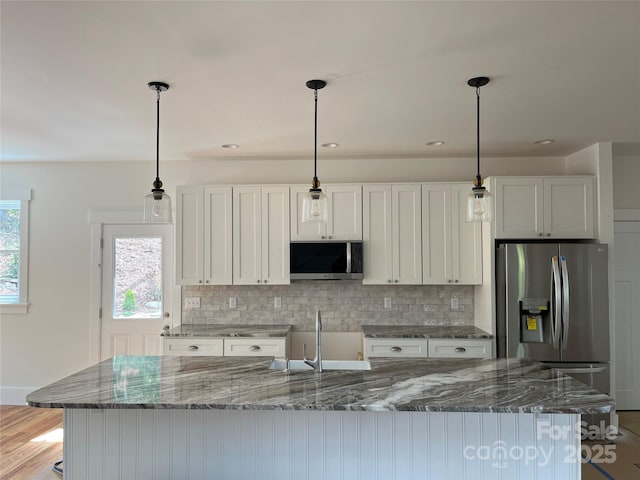 71 Crossings Cir, Fairview, NC 28730 - kitchen with appliances with stainless steel finishes, tasteful backsplash, an island with sink, white cabinetry, and hanging light fixtures