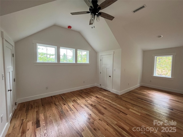 bonus room with lofted ceiling, hardwood / wood-style floors, ceiling fan, and plenty of natural light