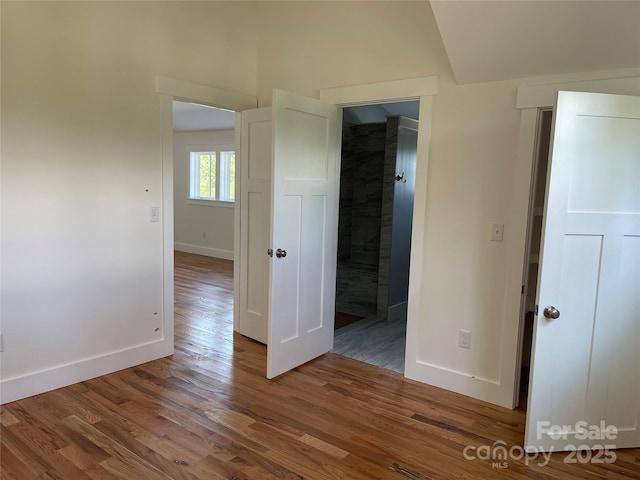 interior space featuring hardwood / wood-style flooring and lofted ceiling