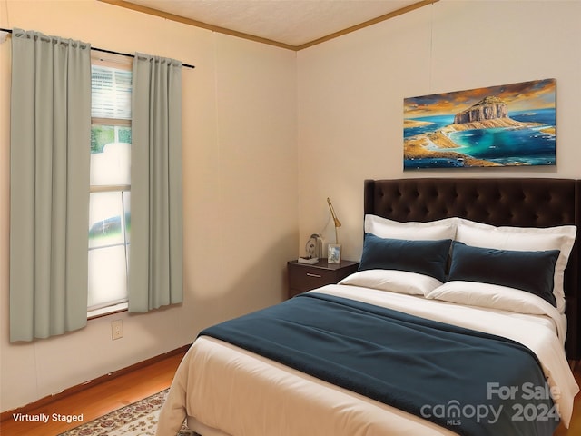 bedroom featuring ornamental molding and hardwood / wood-style flooring