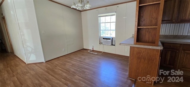 interior space with cooling unit, an inviting chandelier, ornamental molding, and light wood-type flooring