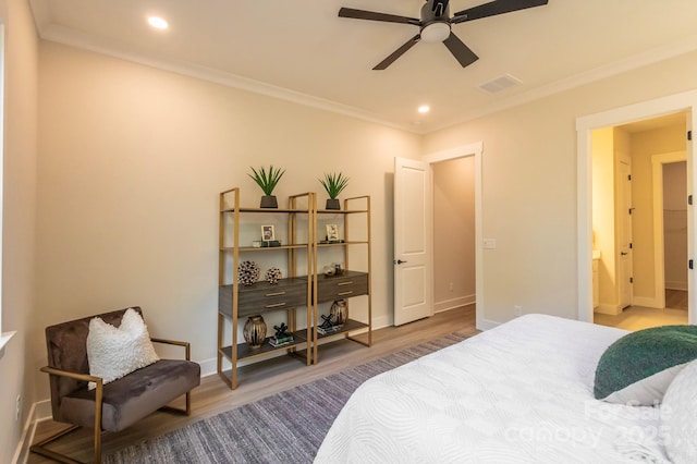 bedroom featuring hardwood / wood-style floors, ceiling fan, crown molding, and ensuite bath