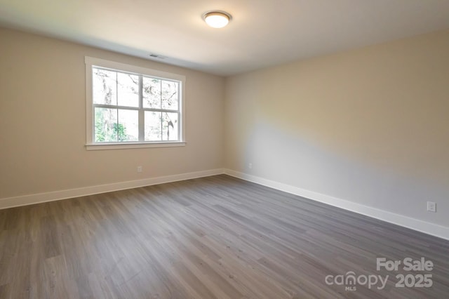 spare room with dark hardwood / wood-style flooring