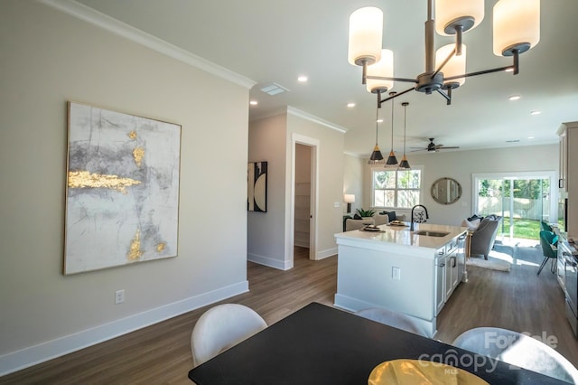2630 Rose St, Charlotte, NC 28208 - kitchen with baseboards, a sink, crown molding, dark wood-type flooring, and an island with sink