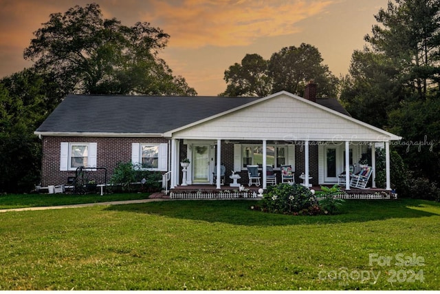 view of front facade featuring covered porch and a yard