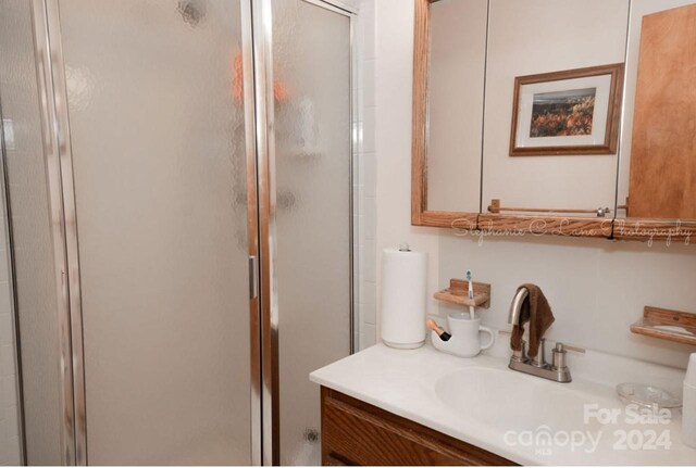 bathroom with vanity and a shower with shower door