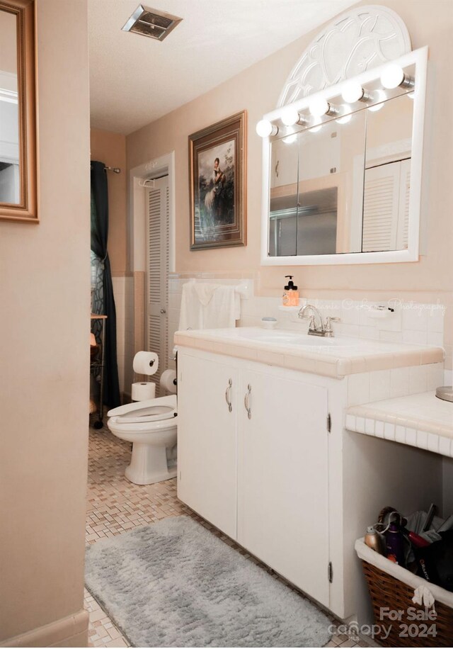 bathroom featuring vanity, toilet, and tile patterned floors