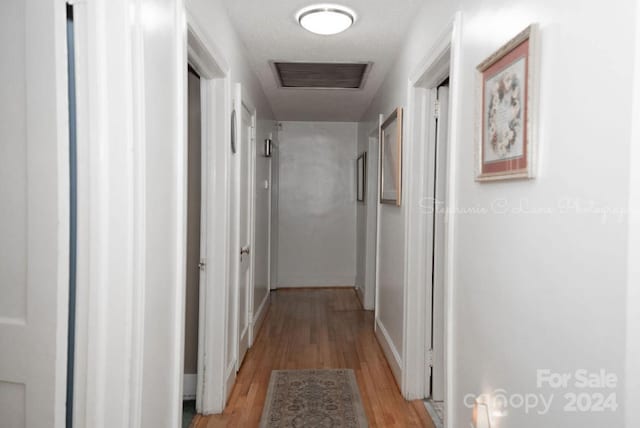 corridor with visible vents and light wood-style flooring