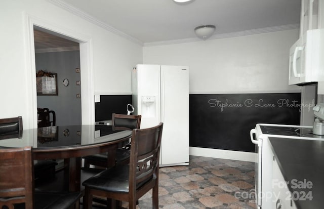 kitchen with white appliances, crown molding, and baseboards