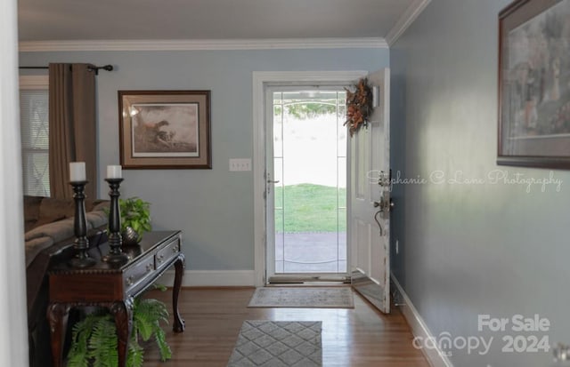 foyer entrance with ornamental molding and hardwood / wood-style flooring