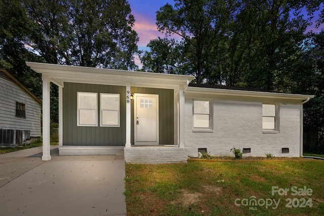 view of front of home featuring brick siding, crawl space, and a lawn