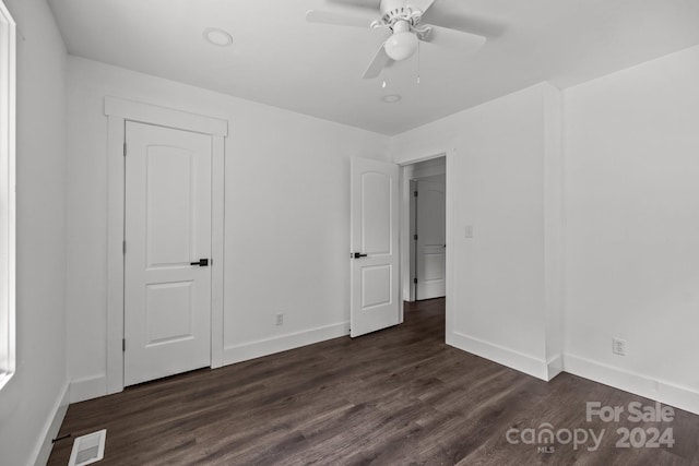 unfurnished bedroom with a ceiling fan, baseboards, visible vents, and dark wood-style flooring