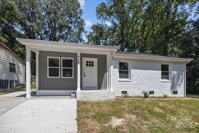 view of front of house with brick siding, crawl space, and a front yard