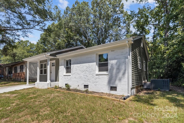 ranch-style house featuring central AC, brick siding, crawl space, and a front yard