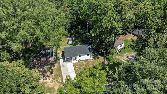 birds eye view of property featuring a forest view