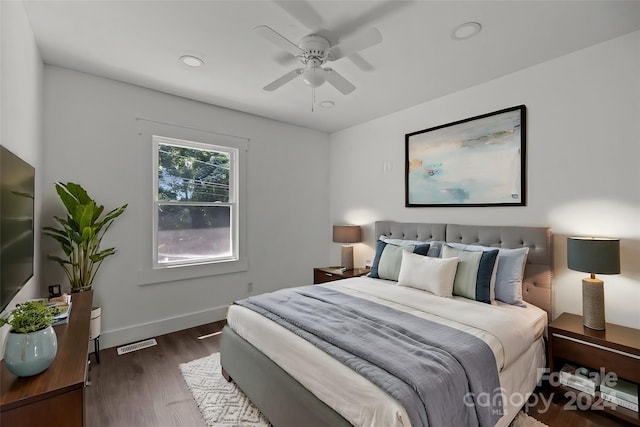 bedroom featuring baseboards, visible vents, ceiling fan, and wood finished floors