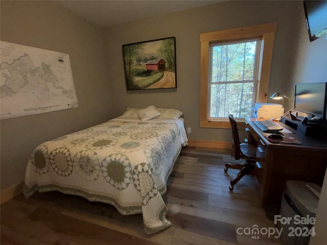 bedroom with dark wood-type flooring