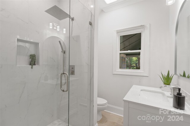 bathroom featuring tile patterned flooring, vanity, toilet, and a shower with shower door