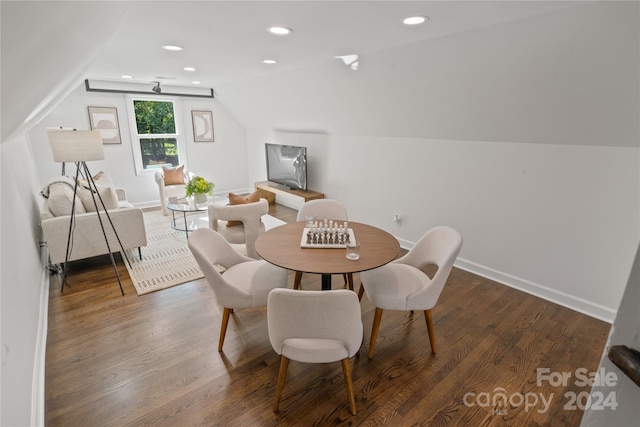 dining space with dark hardwood / wood-style floors and vaulted ceiling