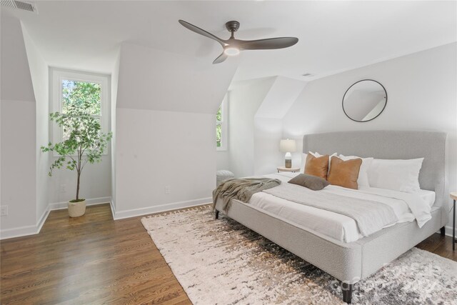 bedroom with ceiling fan, dark wood-type flooring, and vaulted ceiling