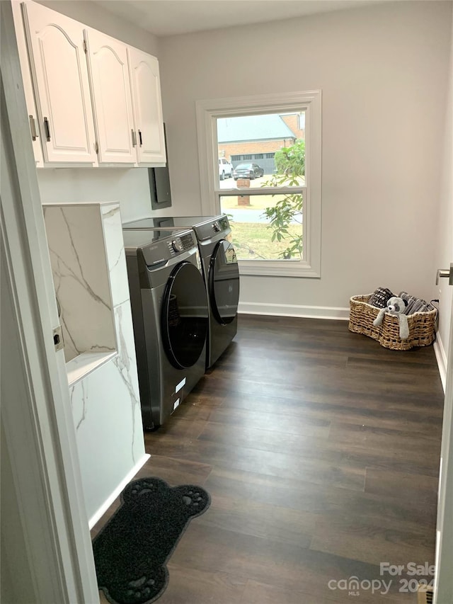 laundry room featuring cabinets, dark wood-type flooring, and washing machine and clothes dryer