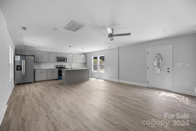 unfurnished living room featuring ceiling fan, sink, and light hardwood / wood-style floors