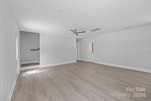 empty room with ceiling fan and light hardwood / wood-style floors