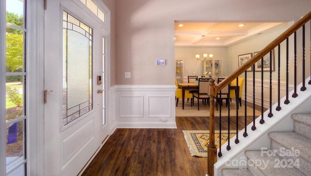 foyer entrance with an inviting chandelier, dark hardwood / wood-style flooring, a wealth of natural light, and coffered ceiling