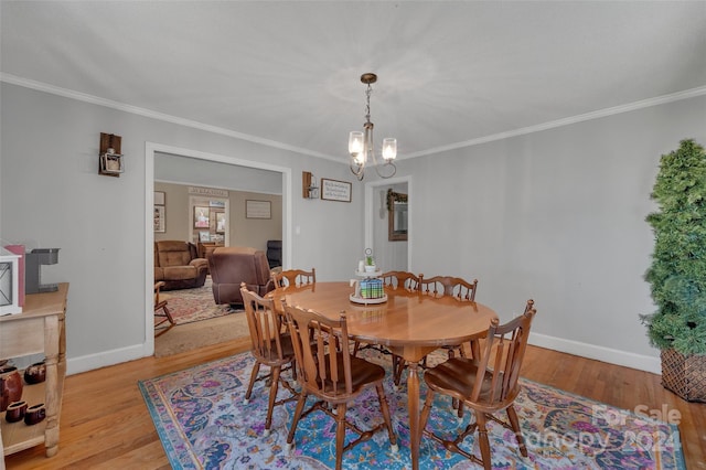 dining area featuring light wood-type flooring, baseboards, and crown molding