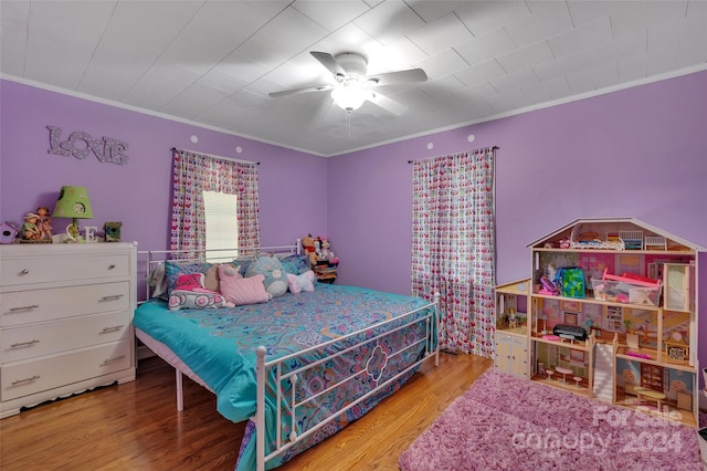 bedroom featuring crown molding, a ceiling fan, and wood finished floors