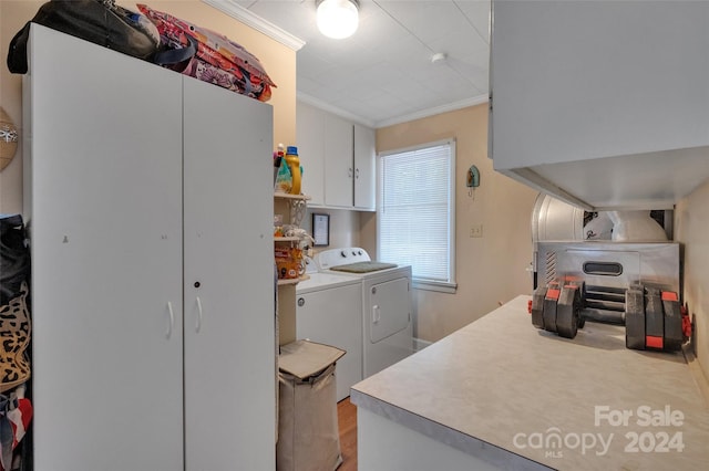 kitchen with light countertops, crown molding, washing machine and clothes dryer, and white cabinetry