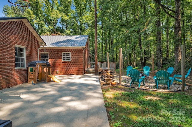 exterior space featuring a wooden deck and a patio