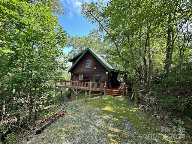 rear view of property featuring a wooden deck