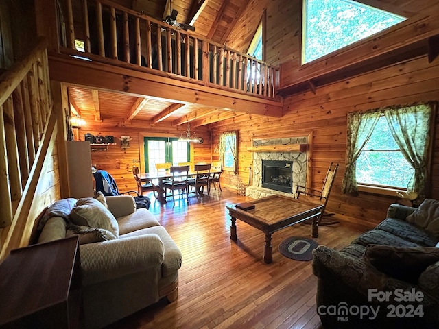 living room with wooden ceiling, ceiling fan, wooden walls, and a stone fireplace