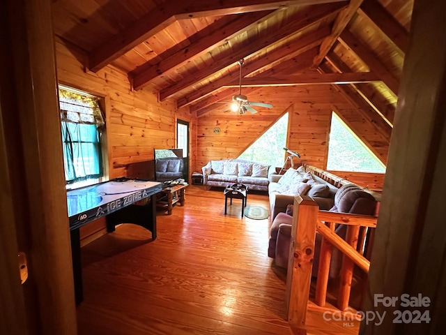 game room with hardwood / wood-style floors, wooden walls, wood ceiling, ceiling fan, and lofted ceiling with beams