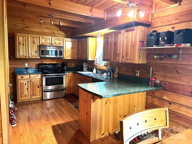 kitchen featuring wooden ceiling, light wood-type flooring, stainless steel appliances, wood walls, and beam ceiling