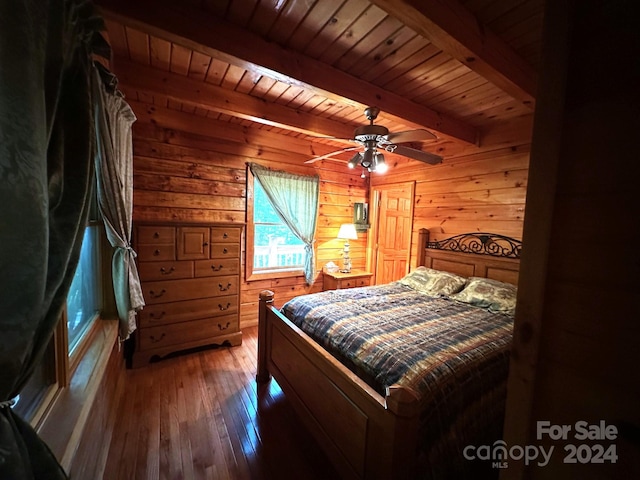 bedroom with hardwood / wood-style floors, wooden walls, ceiling fan, wood ceiling, and beam ceiling