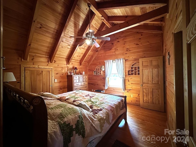 bedroom featuring hardwood / wood-style floors, lofted ceiling with skylight, wooden walls, ceiling fan, and wooden ceiling